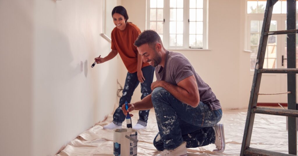 Painting 101: Beginners Step-by-Step Interior Painting Guide 1 man and woman painting and smiling, concept of Painting 101: Beginners Step-by-Step Interior Painting